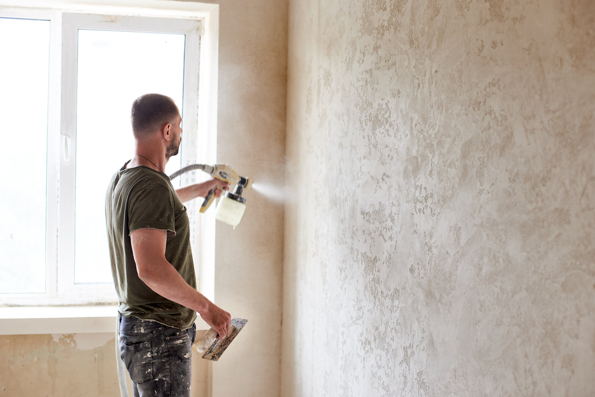 Renovation professional carefully painting a wall